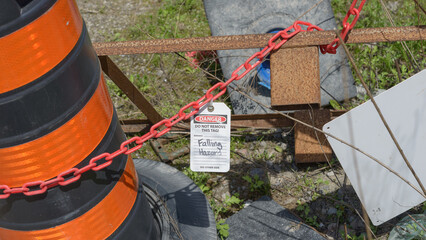 pile of equipment likely from a construction site with a plastic chain and tag 