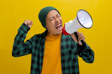 Angry Young Asian man shouts into a megaphone against a yellow background