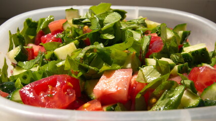 salad of cucumbers, tomatoes and ramson in a container