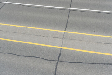yellow and white lines on an asphalt roadway in the city