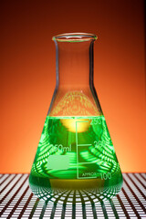 Glass flask placed in a laboratory table with green liquid