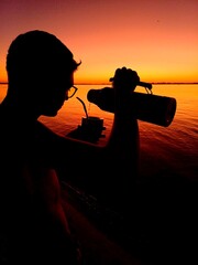 silueta de hombre joven en la playa tomando mate, una costumbre argentina © SantiagoPH