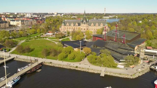 Aerial view of the Nordic Museum and vasa museum in Stockholm, Sweden. Spring, green trees, strong sunshine, people walking near the water and in the parks.