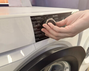 Household appliances in an electronics store. Upgraded washing machine close-up for cleaning clothes. Choosing a washing machine for your home.