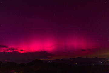 Beautiful violet pink red aurora borealis the northern lights over the horizon in Slovenia.