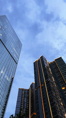 Bottom view of modern skyscrapers in business district against blue sky