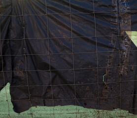 Metal wire fence and synthetic fabric.