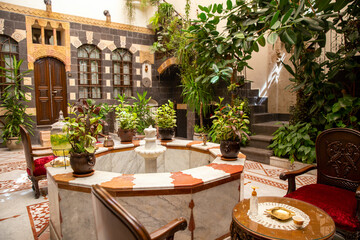 Interior of luxury hotel in oriental style with living plants and fountain in the lobby