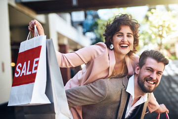 Shopping, sale and portrait of couple in city for clothing deal, discount and store promotion. Fashion, retail mall and happy man and woman for bonding, travel and tourism in urban town on weekend