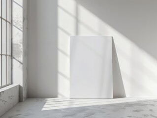 A brightly lit room with a single rectangular white poster leaning against a white wall on the floor Sunlight streams through a window, highlighting the texture of the poster