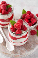Vanilla white chocolate mousse, trifle, panna cotta or parfait with raspberry sauce in a glass jar. Sweet summer dieting dessert.