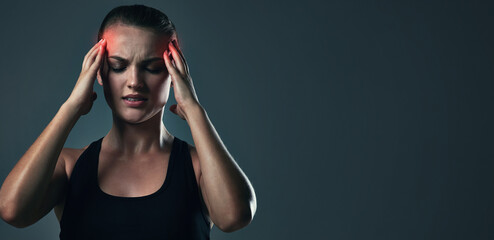 Woman, headache and burnout on exercise in studio on dark background with head pain or...
