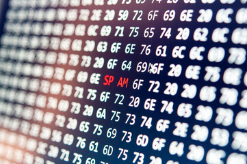 Close-up view of digital screen with red spam alert amidst hexadecimal codes