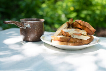 A simple but tasty and hearty breakfast in nature - baked sandwiches with sausage and cheese and a lot of coffee to wake up faster
