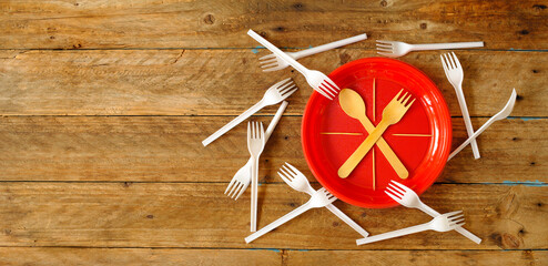 White single-use plastic forks and plates and wooden fork and spoon. Don't use single use plastic...