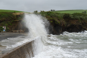 Une vague furieuse se brise avec force sur le rivage lors d'une tempête déchainée, sur la presqu'île de Crozon, offrant un spectacle saisissant de la puissance de la nature