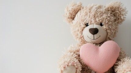 A beige teddy bear clasps a pink heart against a backdrop of white with ample space for text or design