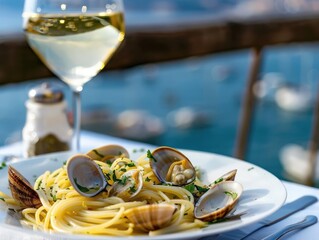 A traditional Italian seafood dish like spaghetti alle vongole spaghetti with clams served with a glass of white wine