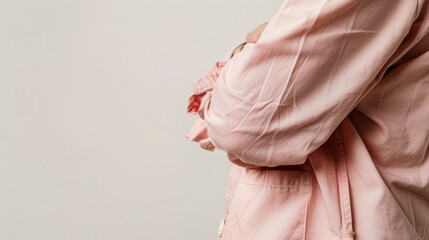 Detail shot of a patients torso in an old rose patient suit, emphasizing the soft hue against a minimalist white backdrop