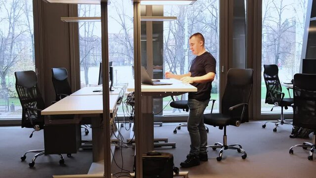 Good job, great idea, excellent result. Success emotion. Successful decision. Businessman is working at ergonomic standing workstation in coworking office. An IT specialist during the online meeting