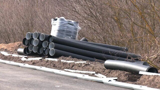 Large diameter black polypropylene pipes for laying communications, drainage systems and heating mains under the road. Modern method and technology for supplying water and sewage.
