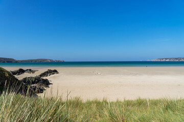 Sur la presqu'île de Crozon, une plage s'anime sous les rayons du soleil estival, invitant à la détente et à l'émerveillement au cœur de l'été.
