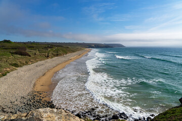 Vue sur la plage de la Palue mêlant galets et sable, caressée par les eaux turquoises de la mer d'Iroise et couronnée d'écume blanche, un spectacle envoûtant sur la presqu'île de Crozon.