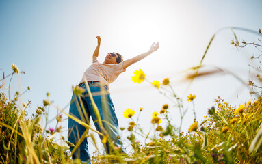 young and cheerful guy dances among the flowers. Handsome man dancing in nature. Summer mood. Happy young guy among blooming flowers, outdoors.