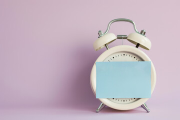 Minimalist Alarm Clock with Blank Blue Note on Purple Background