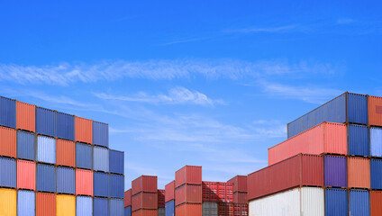 Piles of many cargo containers in terminal shipping yard area at commercial port against blue sky...