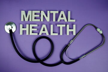 Mental Health alphabet letters and stethoscope on purple background, Healthcare concept