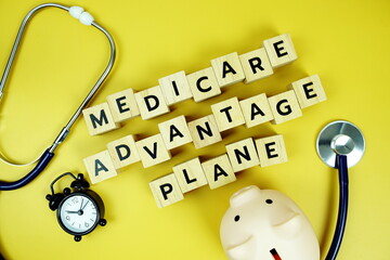 Medicare Advantage Plane with wooden blocks alphabet letters and stethoscope on yellow background