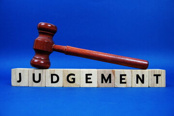 Judgement alphabet letters with wooden blocks alphabet letters and Gavel on blue background