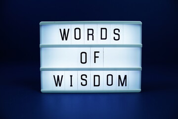 Fototapeta premium Words of wisdom letterboard text on LED Lightbox on blue background