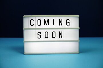 Coming Soon letterboard text on LED Lightbox on blue background