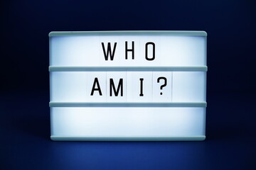 Who am I letterboard text on LED Lightbox on blue background