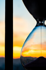 Time passing at sunset with hourglass	
