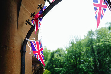 Union Jack bunting seen strewn in an old English church porch. The bunting is used as part of...