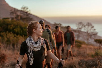 Group of friends hiking at sunset in scenic mountainous landscape