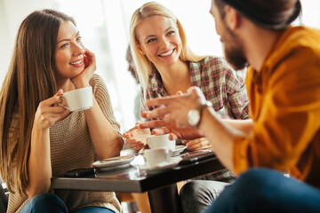 Group of friends enjoying coffee and conversation at cafe