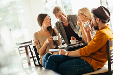 Group of friends enjoying coffee and conversation at cafe