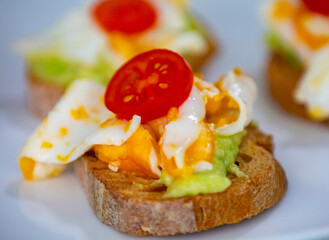 Healthy breakfast, toast with avocado, eggs and tomatoes