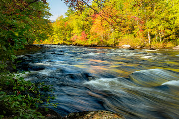 river in the autumn colorful forest on a sunny autumn warm day. USA. Long exposure, blurry water cascades in motion.
New Hampshire