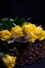 Cup of hot black coffee on coffee beans with yellow roses