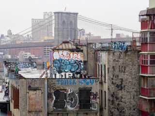 Brooklyn Bridge seen behind graffitied buildings
