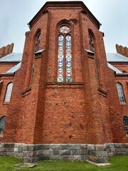 brick wall with stained glass window of old church