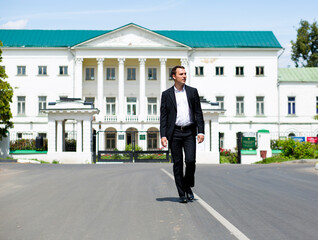 Full length portrait of a young businessman walking down the road
