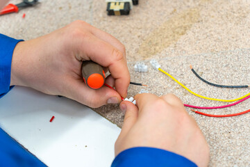 A man doing electronic assembly with colored wires