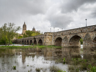 Fototapeta premium Salamanca Roman Bridge over Tornes River with the city skyline in background