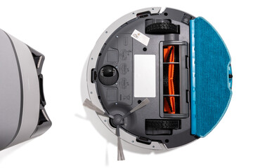 A robot vacuum cleaner is opened up and the blue part is the brush. The robot is on a white...